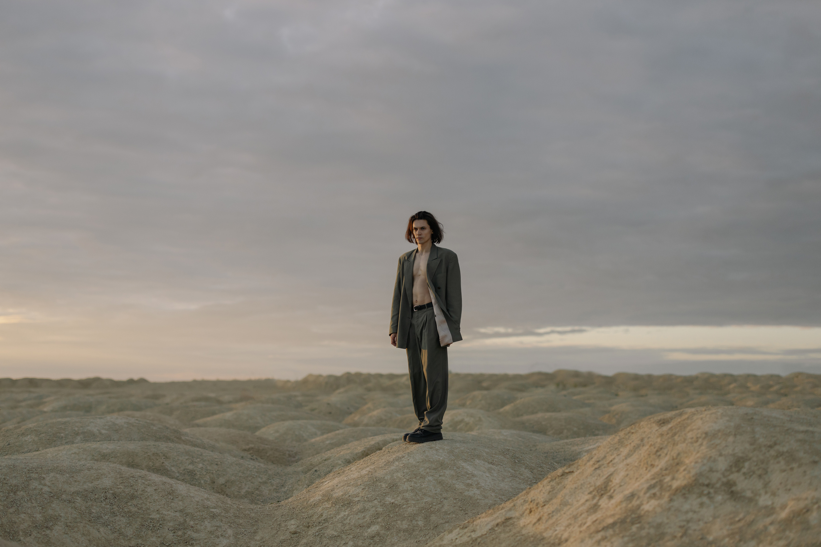 Man in Black Suit Standing on Brown Rock Formation